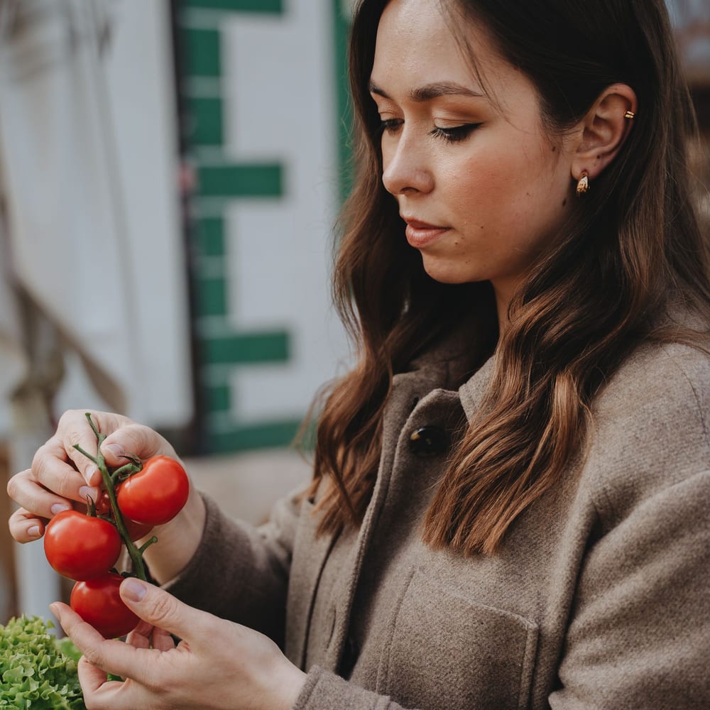 Una vecina elige fruta en el puesto del mercado
