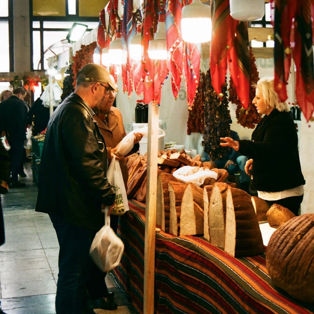 Un cliente compra pan en el puesto de panadería del mercado